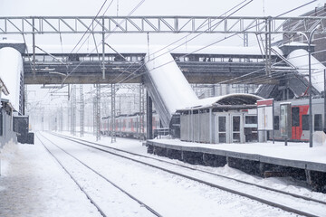 Fototapeta premium Snow covered railway station with snowstorm effects during winter morning hours