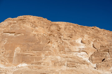 Vast rocky cliffs rise majestically under the clear blue sky of the Sinai desert in Egypt during...