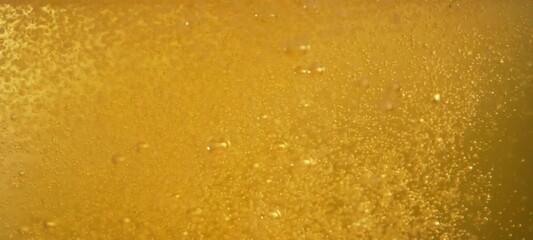 Golden beer pouring into glass with foam and many gas bubbles floating up in slow-motion. Close- up view - Powered by Adobe