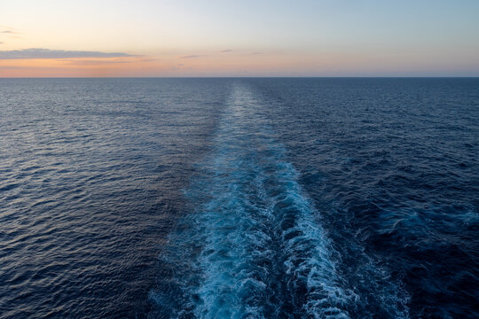 Bugwelle im Meer von Schiff im Abendrot im querformat