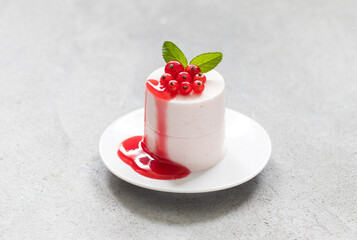 Red Currant Cream pudding cylindrical shape. Panna Cotta. With Red Currant sauce. On a plate....