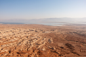 A desert landscape with a blue ocean in the background