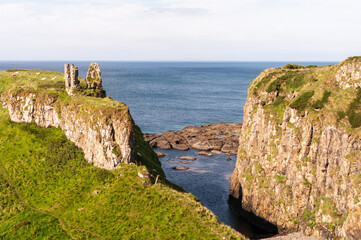 Fototapeta premium A rocky cliff overlooks the ocean, with a small body of water between the two