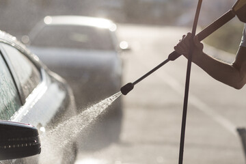 Worker washing car at self-service car wash