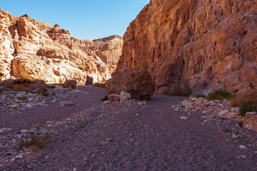 A rocky desert landscape with a large rock in the middle
