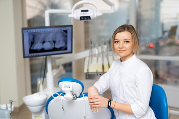 Modern dental clinic pro. A smiling dental professional sits in a modern clinic, ready for patients...
