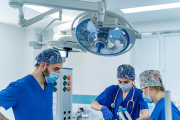 Surgeons at work in hospital. A team of medical professionals in scrubs collaborates in a...