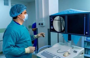 Doc checks imaging tools. A medical professional in scrubs uses imaging equipment in a hospital...