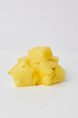 Pineapple chunks forming a small pyramid on white background