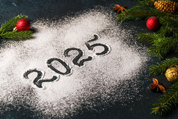 Christmas tree decorations with fir branches and the inscription 2025. New Year or Christmas...