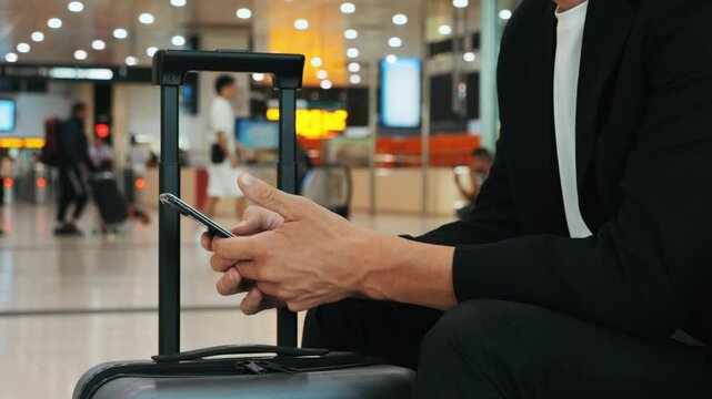 Businessman Uses Laptop, Waiting for a Flight in Airport Terminal or train station, Traveling Entrepreneur Working Online On Computer Sitting in a Boarding Lounge of Airline Hub with Airplanes