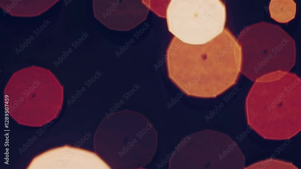 Poster abstract video with a close-up, top-down angle showing soft-focus red bokeh lights against a dark ba
