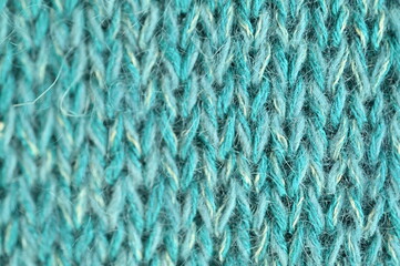 turquoise  texture of knitted wool fabric as a background, teal smooth symmetrical lines of hand-knitted needlework pattern	
