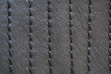 black leather texture close-up, seams on leather jacket as background, black natural leather as...