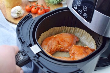 Cooking chicken legs in air fryer, using a disposable paper insert.