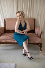 Beautiful blonde pinup girl, glamorous woman, American model in classy green dress