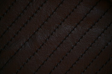 black leather texture close-up, seams on leather jacket as background, black natural leather as...