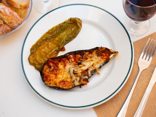 Plate of a delicious dish of baked stuffed eggplant with cheese rubbed on top