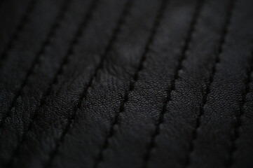 black leather texture close-up, seams on leather jacket as background, black natural leather as...