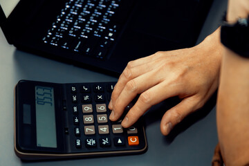 Cropped hand businessman calculating financial and accounting annual report showing digit gross...