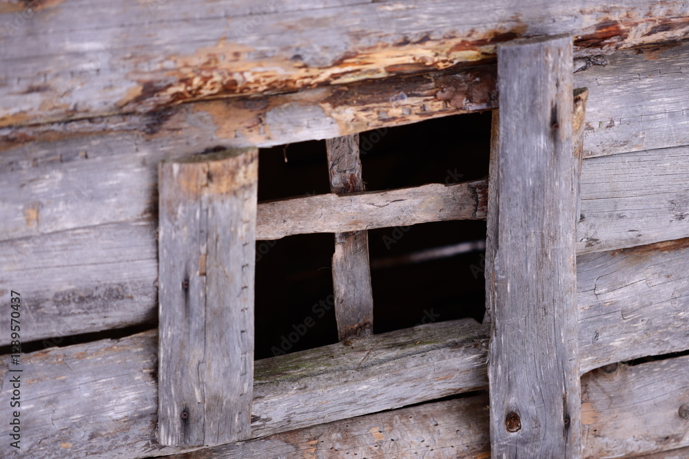 Poster a close-up shot of a wooden window frame in a rustic building.