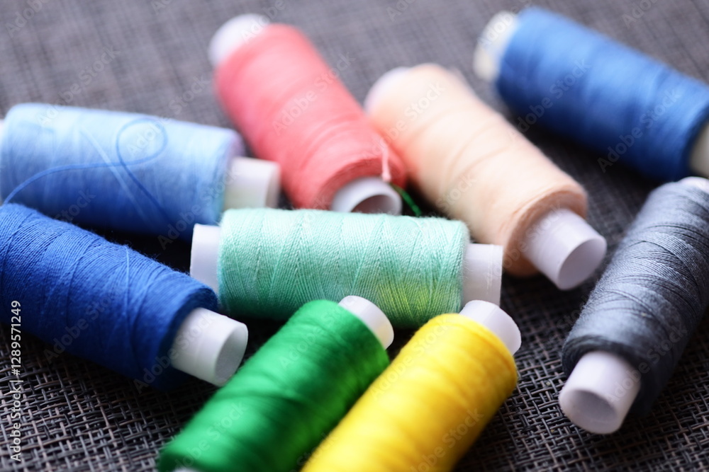 Poster A collection of thread spools arranged neatly on a table, suitable for craft or sewing projects.