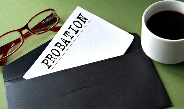 PROBATION - word on a white sheet of paper on a background of a black convers and a cup of coffee