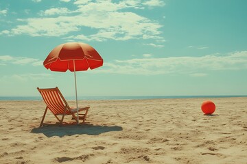 A red umbrella and chair on a sandy beach