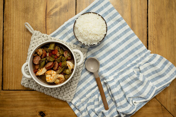 Cajun shrimp and sausage gumbo with rice on a wooden table