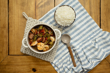 Cajun-style shrimp and sausage gumbo with rice on a wooden table