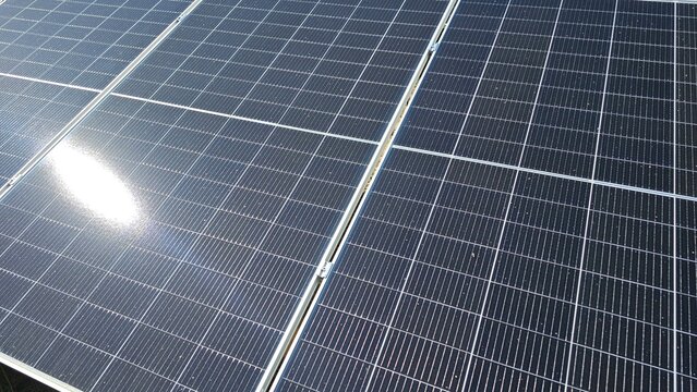 Close-up of a solar panel surface with a bright, reflective background, symbolizing renewable energy and sustainability