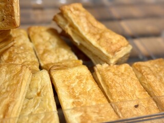 A closeup view of flaky, golden pastry snacks, which are ideal for finger appetizers or casual gatherings and events. 