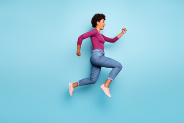 Obraz premium Full length body size photo of cheerful charming cute jumping fast quick woman running towards shopping mall for sales wearing jeans denim isolated over vivid color blue background
