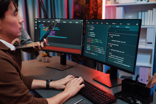 Serious of IT developers discussing intelligent website development coder system running data online two screens with laptop showing information network at neon light room at modern office. Infobahn.