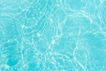 Blue water with ripples on the surface. Defocus blurred transparent blue colored clear calm water surface texture with splashes and bubbles. Water waves with shining pattern texture background.
