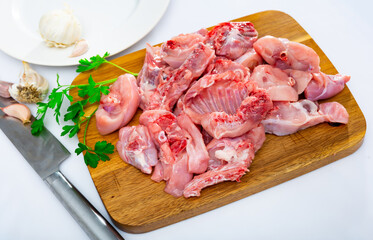 Raw rabbit meat with spices and herbs on wooden cutting board