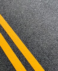Double yellow lines freshly painted on a resurfaced asphalt road in the UK to restrict parking. 