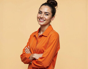 Side view young smiling Caucasian woman she wear orange shirt casual clothes hold hands crossed folded look camera isolated on plain pastel light beige background studio portrait. Lifestyle concept