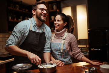 Happy couple cooking together in cozy kitchen