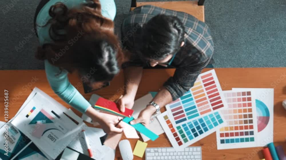 Poster top down view of smart designer helping manager choosing color from colored palettes. aerial view of