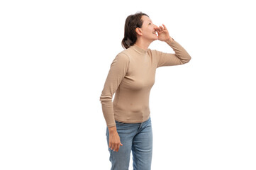 A young woman in a beige top joyfully shouting with a smile against a white background.