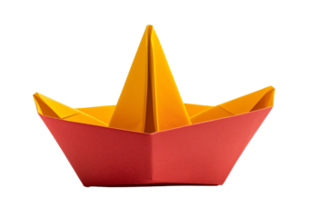 Brightly colored origami paper boat in red and yellow resting on a table indoors