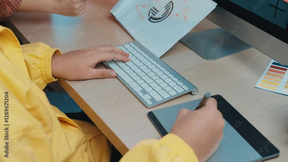 Poster a focused creative professional in a striking yellow jacket utilizes a tablet and computer in a mode
