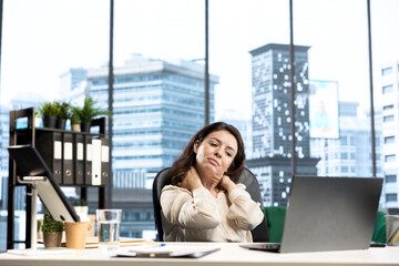 Female CEO dealing with office syndrome from incorrect posture at desk, having a neck muscle cramp...