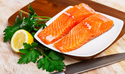 Salmon fillet on cutting board with lemon and parsley. Healthy food