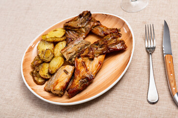 Baked crispy and spicy rabbit in glaze served with potatoes slices.