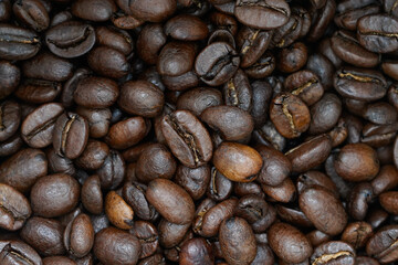 Captivating close-up of deeply roasted coffee beans, showcasing their rich, dark texture and intricate details. 
