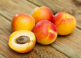 Whole and half fresh apricots on wooden table. Healthy vegetarian ingredient