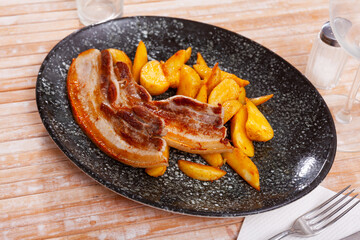 Delicious roasted pork belly strips with baked potatoes