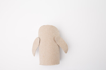 Recycled craft project with cardboard toilet paper roll figure on white background. Creative use of household waste for DIY projects or educational activities. Ideal for educational content creators.